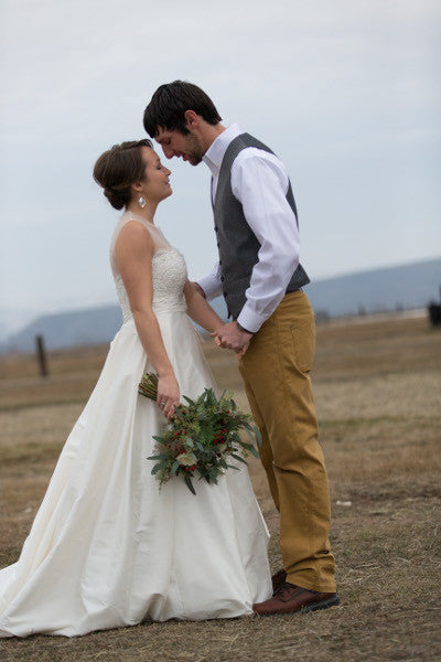 Husband and wife on wedding day in field